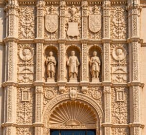 Close-up of the ornate Spanish Colonial Revival façade of the San Diego Museum of Art in Balboa Park, featuring carved figures, decorative shields, and intricate stonework.